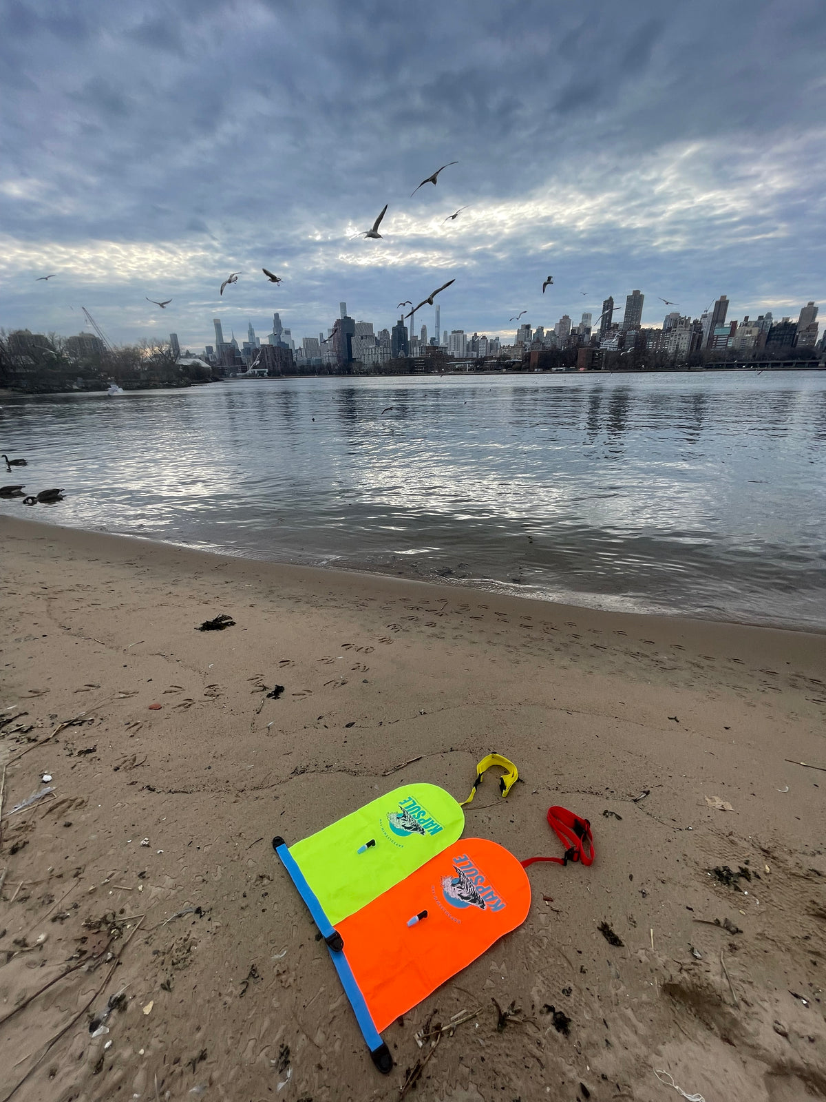 KAPSULE Atlas swim buoy neon orange high-visibility open water safety float on beach